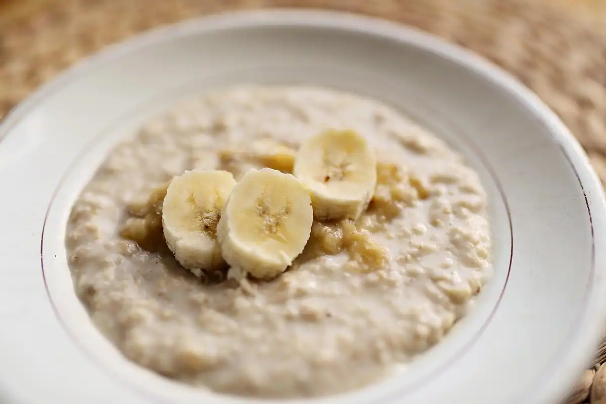 Terci de ovăz cu felii de banană într-o farfurie, ingredient de bază pentru batoane de casă