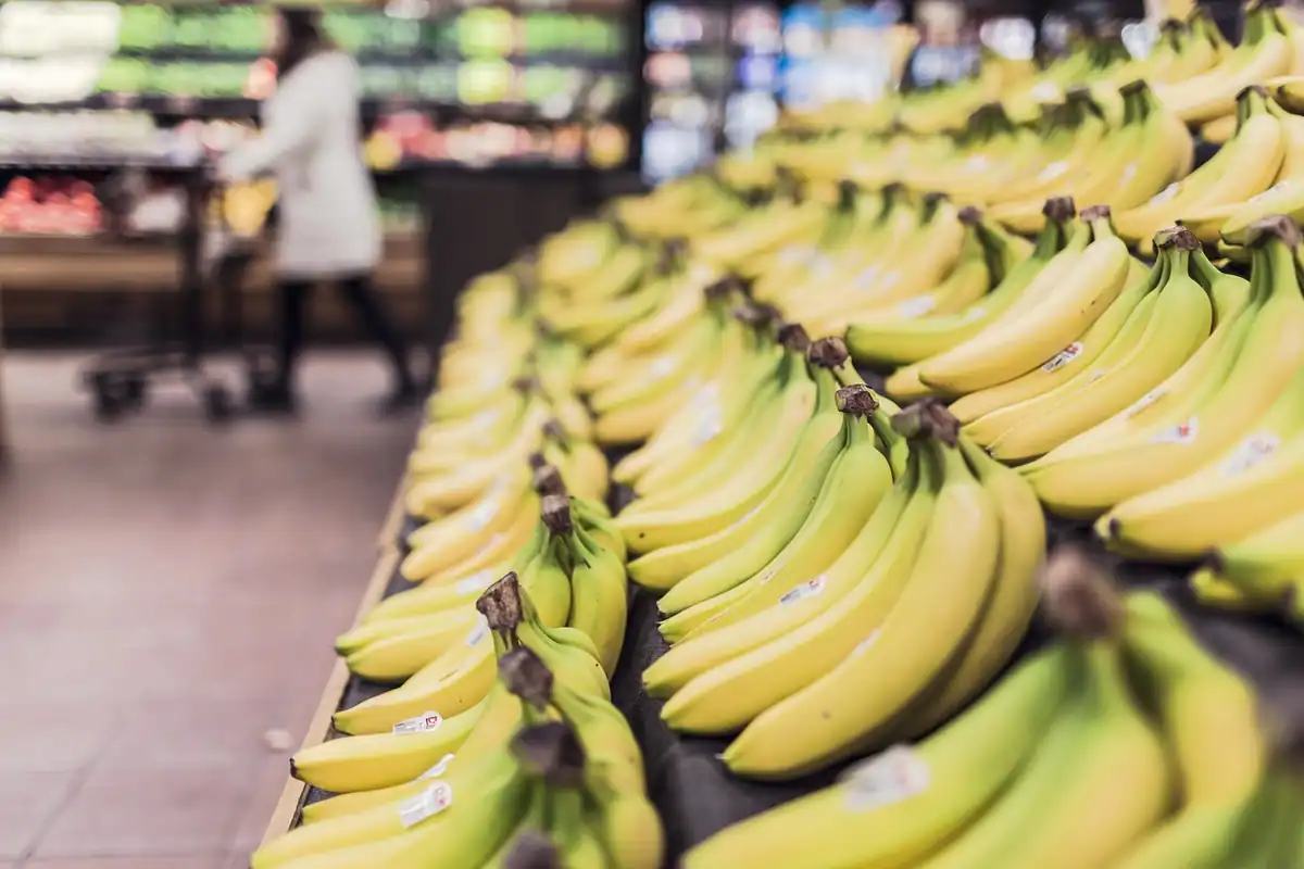 Banane galbene aranjate pe un raft de magazin, fructe alese pentru coșul săptămânii