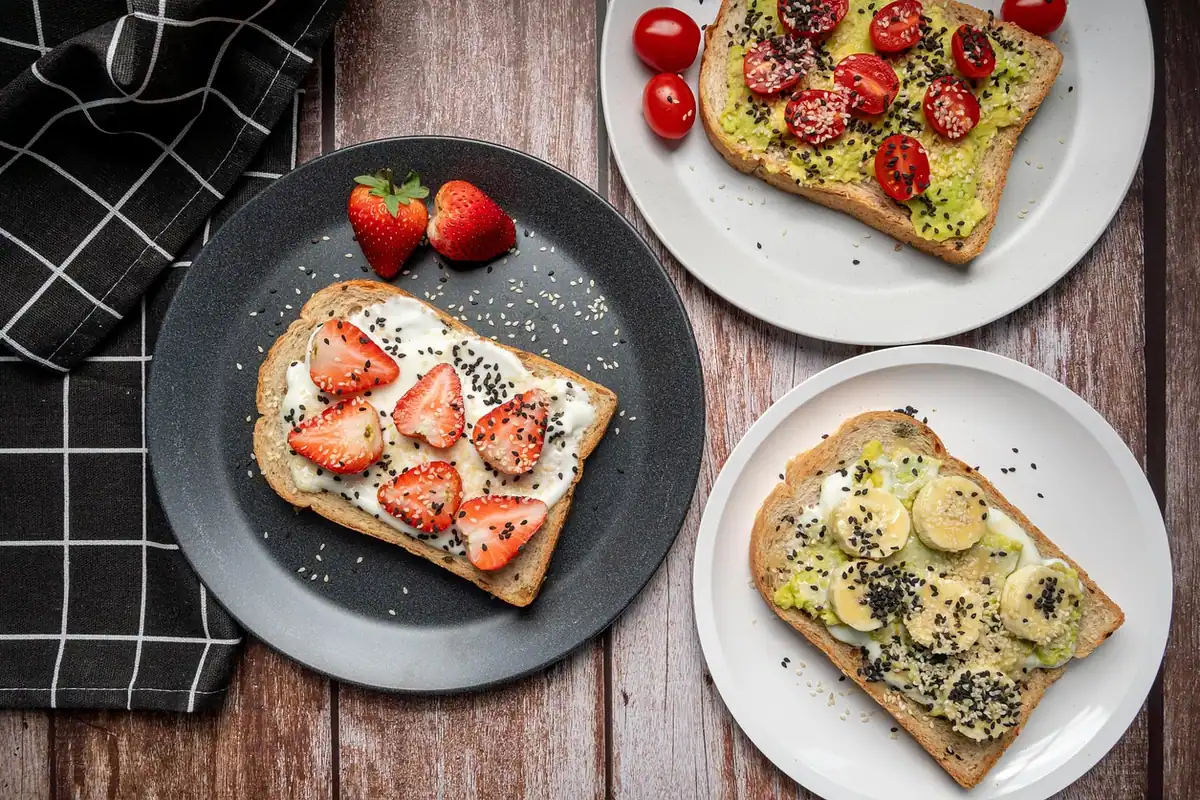 Două felii de pâine prăjită cu avocado, căpșuni și semințe, idee din resturi reinventate