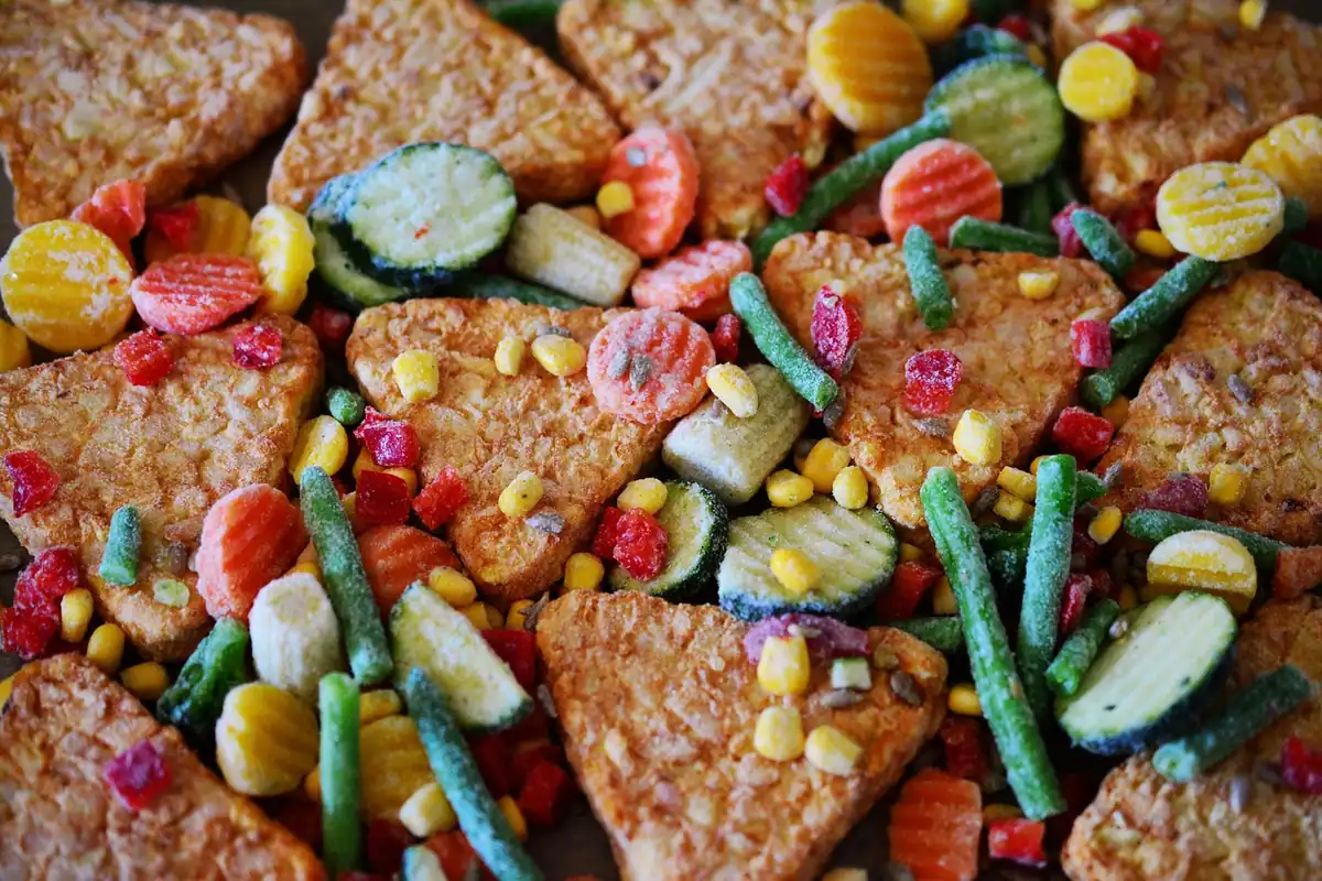 Bucăți de pește pane cu un amestec colorat de legume congelate gătite