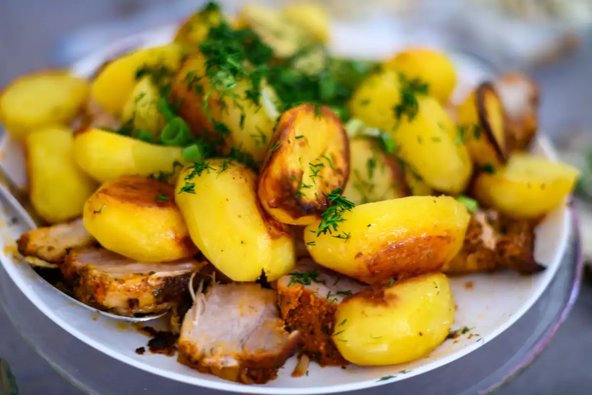Cartofi rumeniți cu carne și mărar proaspăt într-o farfurie, o masă de sărbătoare moderată