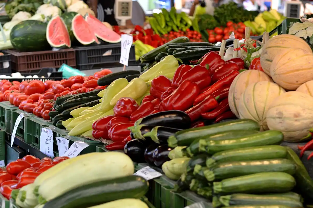 Taraba de piață cu pepene, ardei, dovlecei și dovleci, produse proaspete de ales