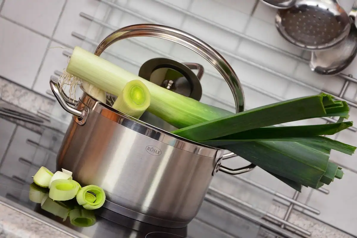 Oală inox cu praz proaspăt și legume tăiate, ingrediente pentru supa-cremă